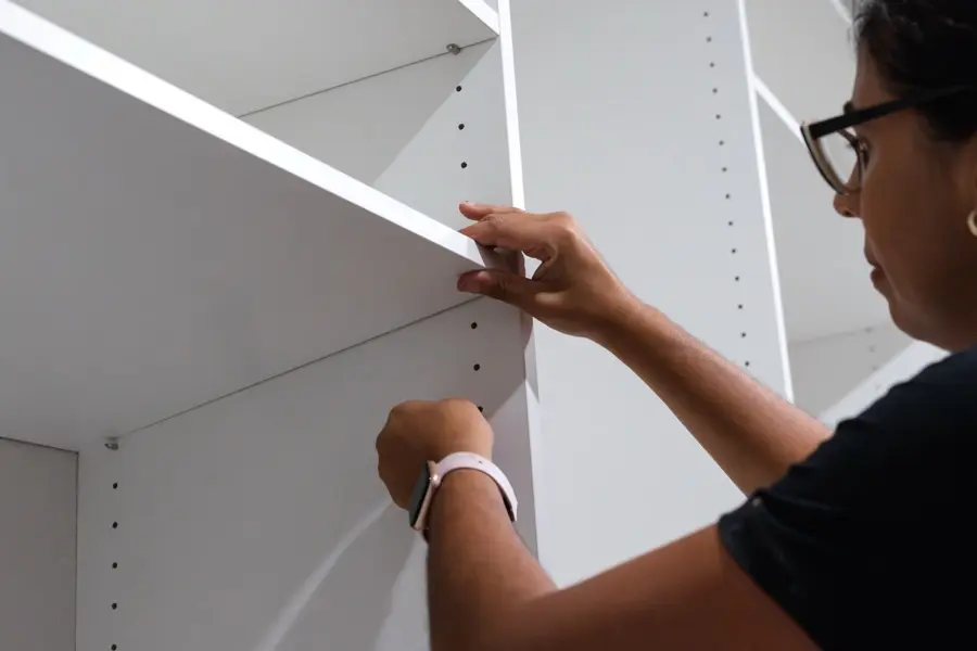 Installer setting a shelf with precision hardware